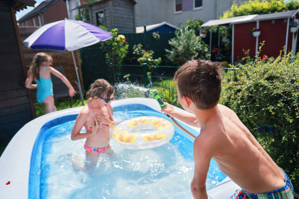 istock Backyard Water Fun Cute Little Kids Playing in Swimming Pool 1323735068