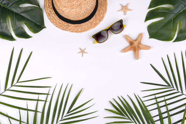 istock Beach accessories: glasses and hat with shells and sea stars on a white background 1323735521