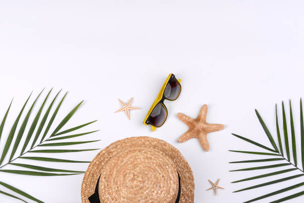 istock Beach accessories: glasses and hat with shells and sea stars on a white background 1323735587