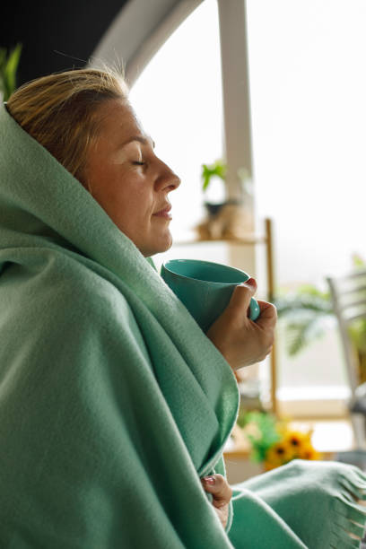 istock Woman enjoying coffee in bed under a cozy blanket 1323735737