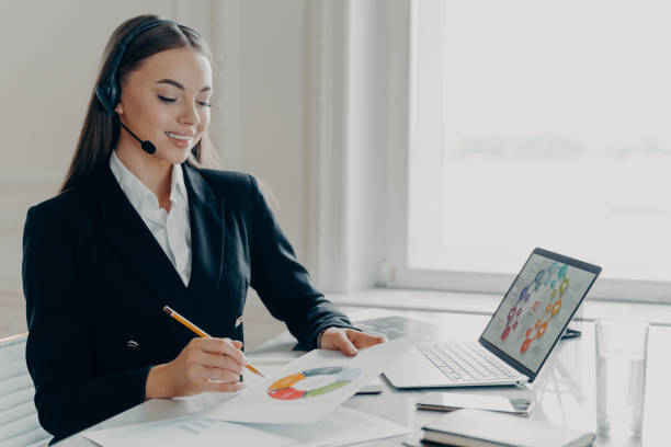 istock Satisfied female entrepreneur in headset analyzing project results during web conference 1323736461