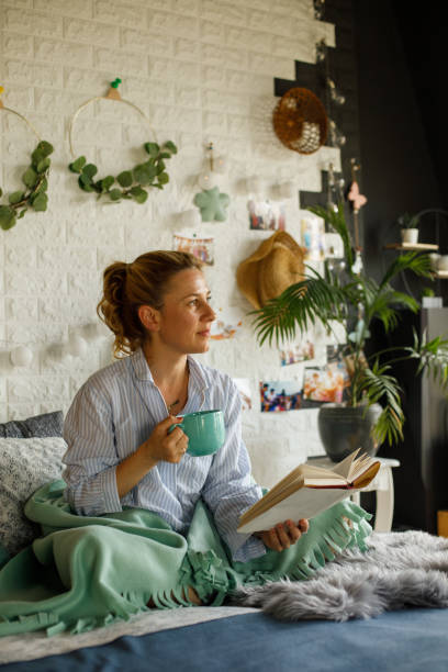 istock Contemplating while reading a book in bed and enjoying a cup of coffee 1323736535