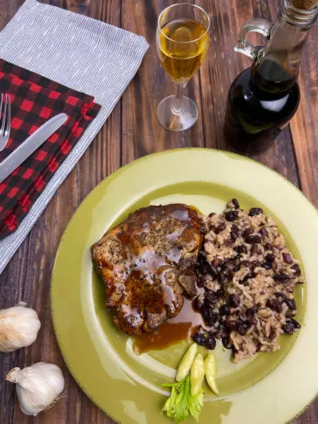 Center cut bone-in pork chop with balsamic drizzle served with black beans and rice.