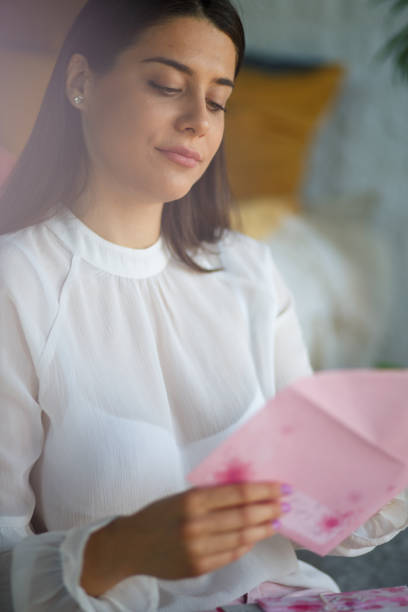istock Young woman opening a letter she received in mail 1323737457
