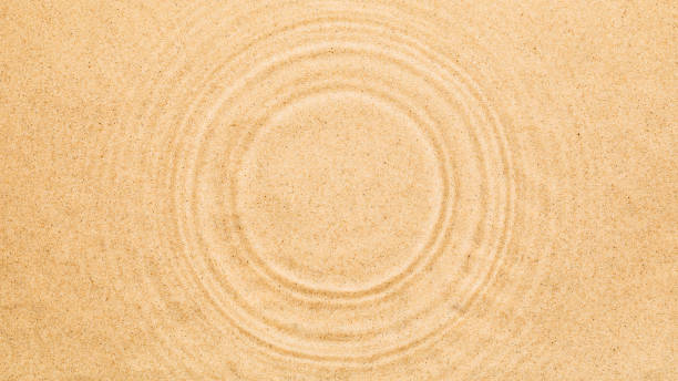 istock Water rings on water surface over sand. Summer texture background with round copy space 1323738147