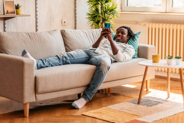 istock Handsome man relaxing at home and texting on phone 1323738564