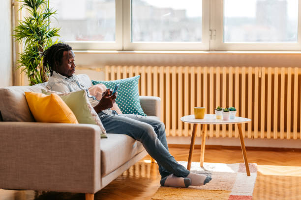istock Handsome man relaxing at home and texting on phone 1323738580