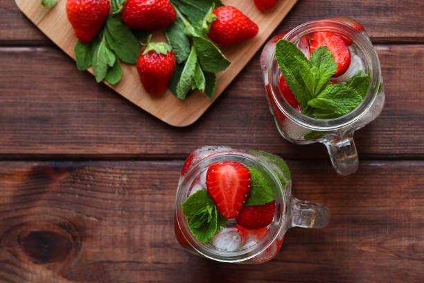 istock Summer refreshment drinks. Fresh strawberry lemonade with ice and mint on a wooden table. Close-up, selective focus, top view 1323738607