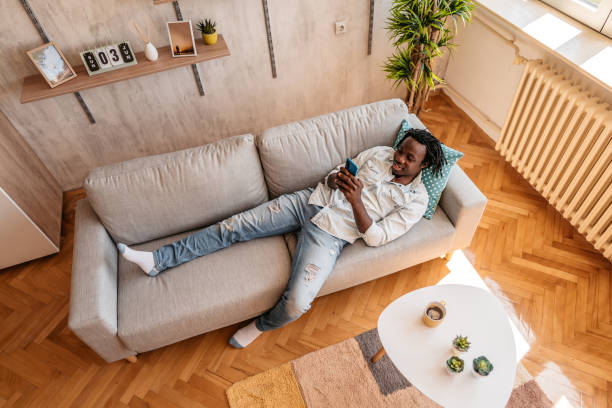 istock Handsome man relaxing at home and texting on phone 1323738668