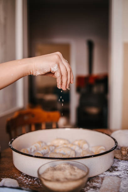 Woman putting sesame seeds on the rolls