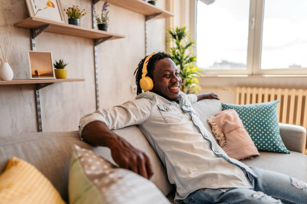 istock Man enjoying music and relaxing on sofa 1323739401