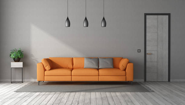 istock Orange sofa in a gray room with closed door 1323739770