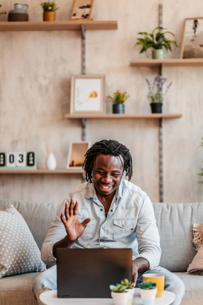 istock Man making online video call on laptop on sofa 1323739787