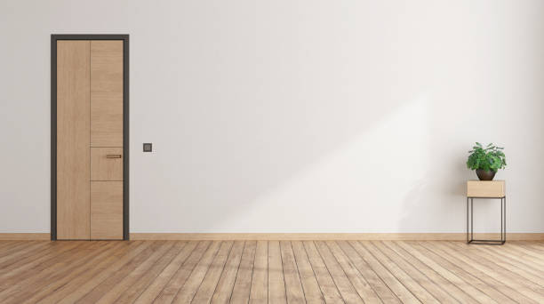 istock Empty room with closed door and houseplant 1323739891