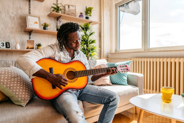 istock Man playing acoustic guitar at home 1323740213
