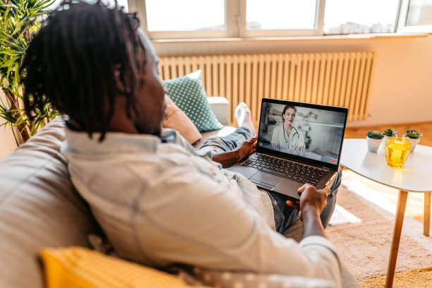 istock Man Video Conferencing With Doctor On Laptop 1323740985