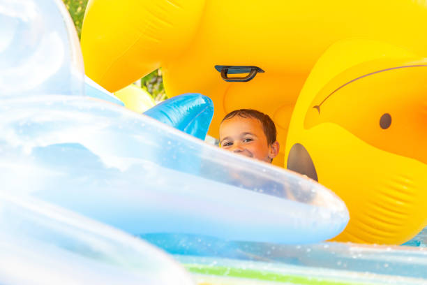 istock Young Boy Playing in Swimming Pool With Inflatables 1323741271
