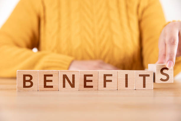 Woman Arranging Wooden Cubes and Writing Benefits Woman is arranging wooden cubes and writing word Benefits benefits stock pictures, royalty-free photos & images