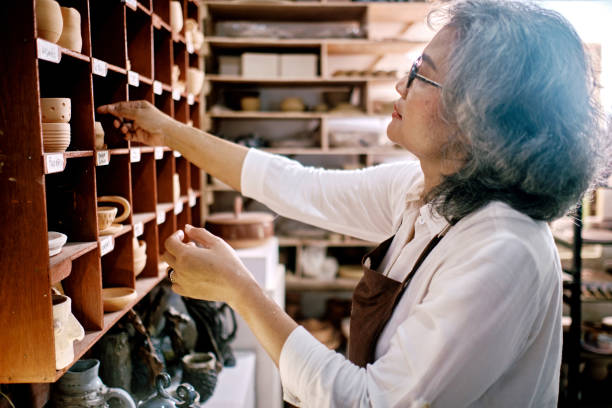 femmes moyennes travaillant sur la fabrication d’objets en argile dans l’atelier de poterie - groupe moyen dobjets photos et images de collection