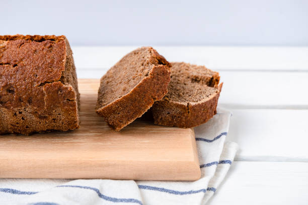 istock Sourdough rye bread sliced on a cutting board on white wooden table with 1323745841