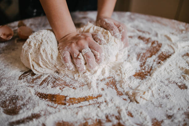 istock Woman kneading the dough on the table 1323746217