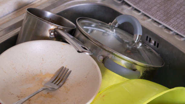 the kitchen utensils in the wash basin need to be washed. a pile of dirty dishes in the kitchen sink. kitchen utensils need washing. homework concept. - sink domestic kitchen kitchen sink faucet imagens e fotografias de stock