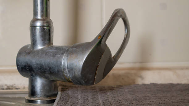 istock An old single lever valve with a leak. Chrome-plated basin mixer with running water on the basin. 1323747314