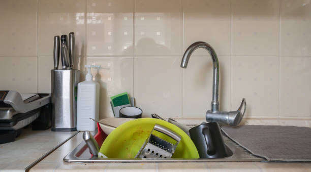 the kitchen utensils in the wash basin need to be washed. a pile of dirty dishes in the kitchen sink. kitchen utensils need washing. homework concept. - sink domestic kitchen kitchen sink faucet imagens e fotografias de stock