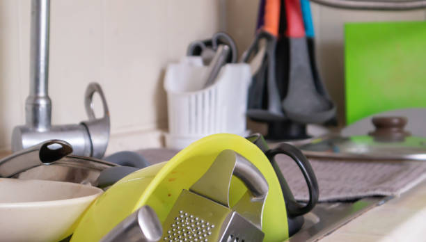 the kitchen utensils in the wash basin need to be washed. a pile of dirty dishes in the kitchen sink. kitchen utensils need washing. homework concept. - sink domestic kitchen kitchen sink faucet imagens e fotografias de stock