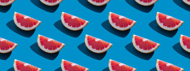 istock Seamless pattern of orange grapefruit with shadow on a blue background. Banner. Summer vacation minimal trendy concept. Healthy eating habits. 1323750588