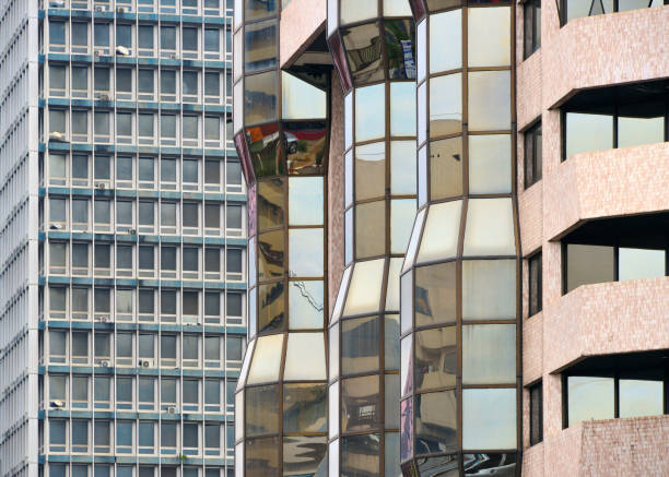 A glass facade with red lines and small balconies reflects its surroundings. The architecture has a dynamic feel.