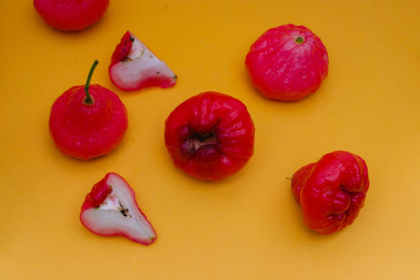 istock Freshly rose apple fruit isolated on orange background. Also known as jambu air Merah (Syzygium aqueum), jambu Semarang (Syzygium samarangense), Jambu Bol, or Malay Apple (Syzygium malaccense) 1323756668
