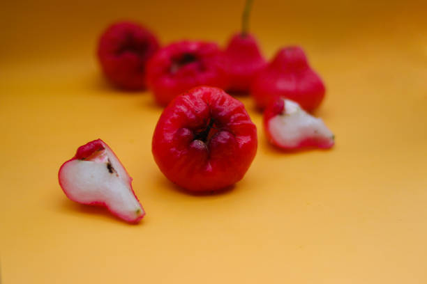 istock Freshly rose apple fruit isolated on orange background. Also known as jambu air Merah (Syzygium aqueum), jambu Semarang (Syzygium samarangense), Jambu Bol, or Malay Apple (Syzygium malaccense) 1323756849
