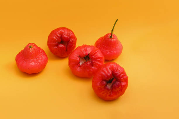istock Freshly rose apple fruit isolated on orange background. Also known as jambu air Merah (Syzygium aqueum), jambu Semarang (Syzygium samarangense), Jambu Bol, or Malay Apple (Syzygium malaccense) 1323757848