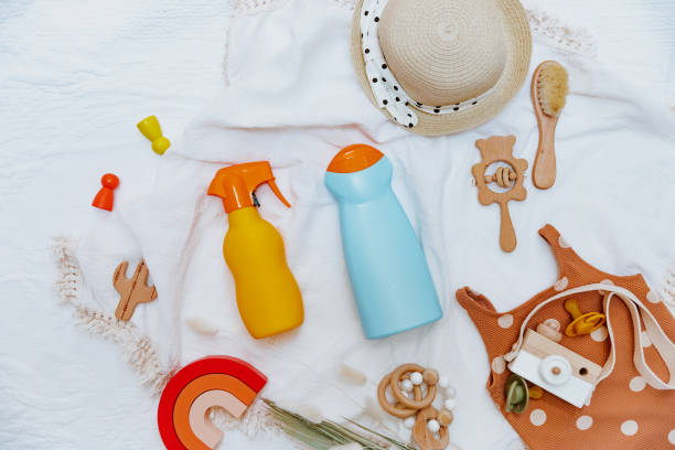 istock Beach kids accessories flat lay and summer background top view. Sun hat, bib, sunscreen bottle. 1323759805