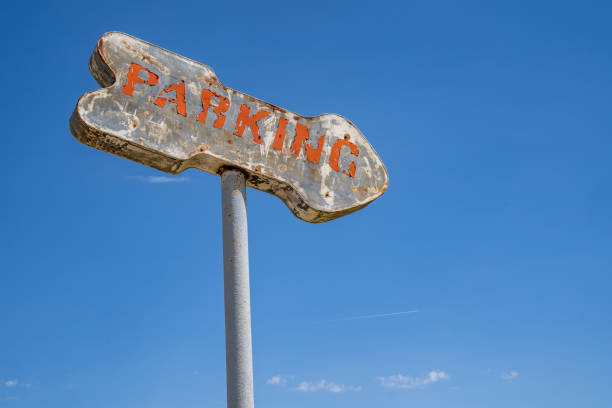 istock Old rusty generic parking sign with an arrow against a blue sky 1323765839