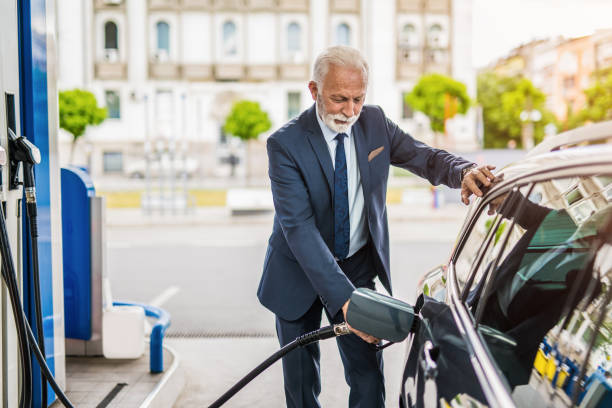 istock Senior man refueling his car the gas station. 1323768352