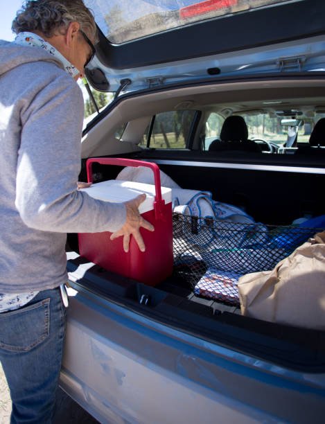 istock NM Road Trip: Senior Man Putting Cooler in Hatchback 1323769234