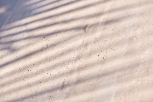 istock Trendy texture with tropical palm leaf shadow on beige natural stone wall. Minimal trendy abstract concrete texture background for product presentation 1323770937