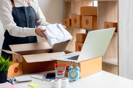 Close uo of female start up small business owner writing address on cardboard box at workplace.small business entrepreneur SME , working with box at home, Online selling, e-commerce, packing concept