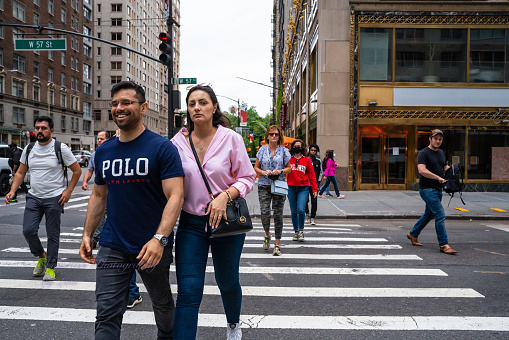 New York City, New York, USA - June 12, 2021: Midtown Manhattan street scene with people crossing the street at crosswalk.