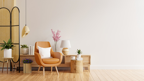 Living room interior wall mockup in warm tones with leather armchair on white wall background.3d rendering