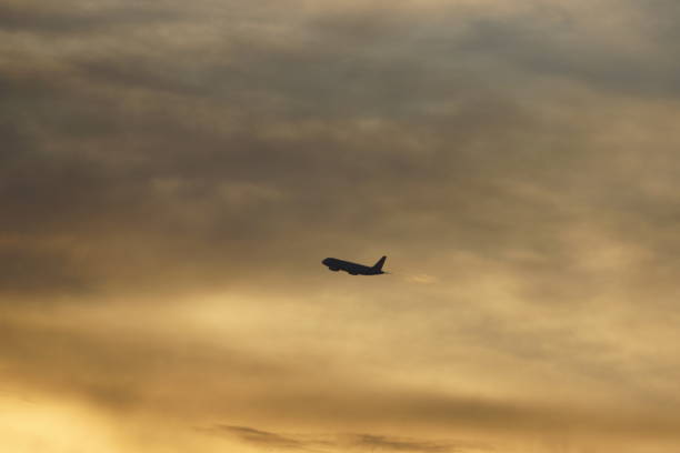 istock Golden Sky and the plane soaring 1323787144