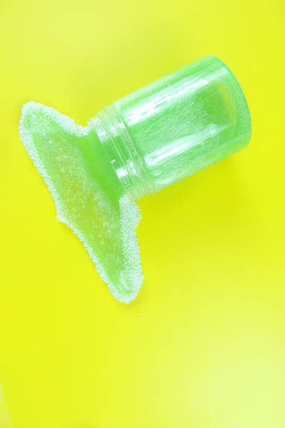 istock Green glitter slime with white decorative balls and sparkles flows out of the container 1323791102