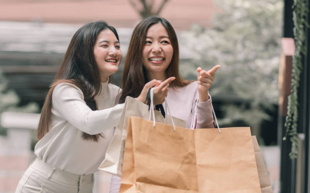 istock Two asian women doing window shopping together 1323794509