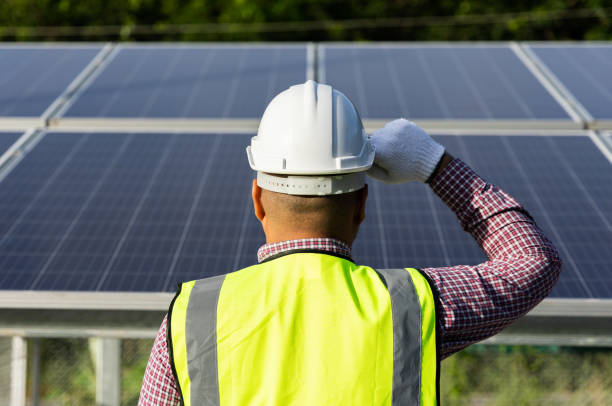 istock Young asian electrical engineer standing in front of Solar cell panels farm. He checking and installing. Solar generator power concept. 1323796501