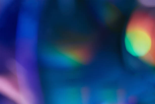 Blurred rainbow colored light flare background. Defocused film texture background with colored lights on dark background. Blurred rainbow color light flare for photo effects refraction photos stock pictures, royalty-free photos & images