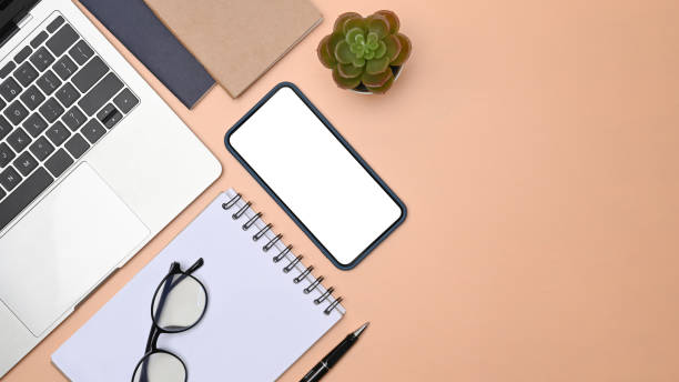 istock Mock up laptop, smart phone and notebook on beige background. 1323803196