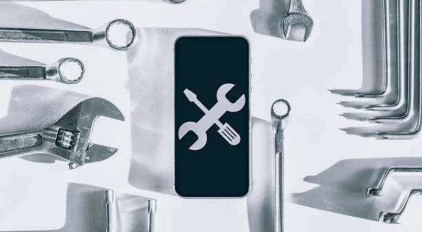 istock Repair phone. Technician workplace with phone and special repairing tools. Disassembling, diagnostic and repairman smartphone. 1323803489