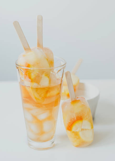 istock Summer cold drinks, citrus fruit cocktail - orange and lemon, with ice, and popsicles on a stick. 1323806996